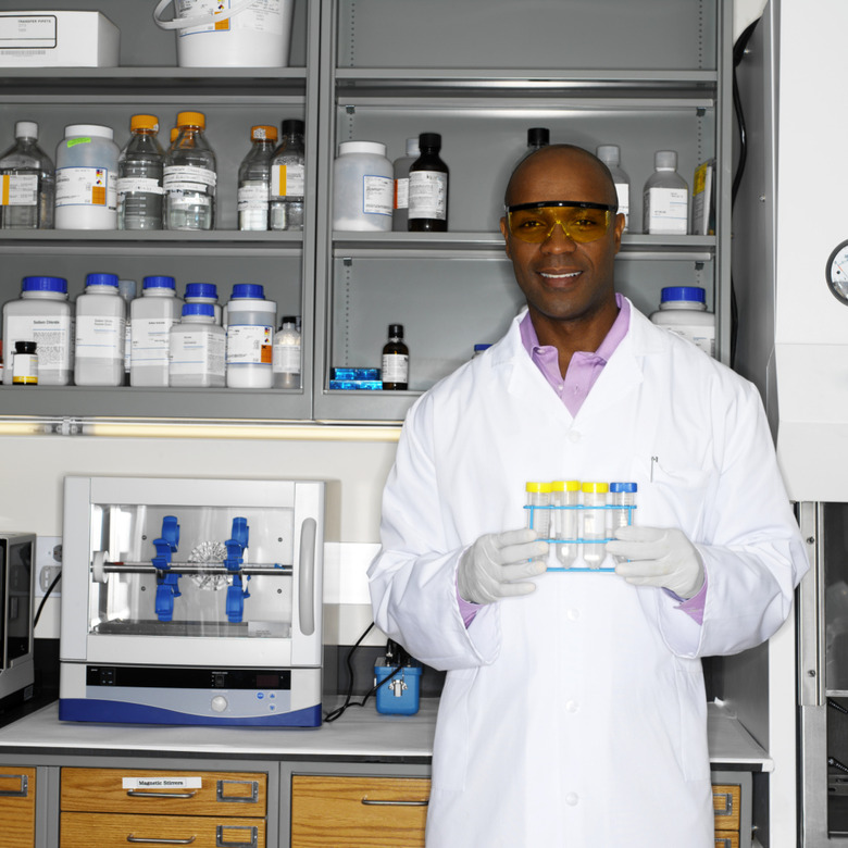 Portrait of a young male microbiologist holding a rack of test tubes