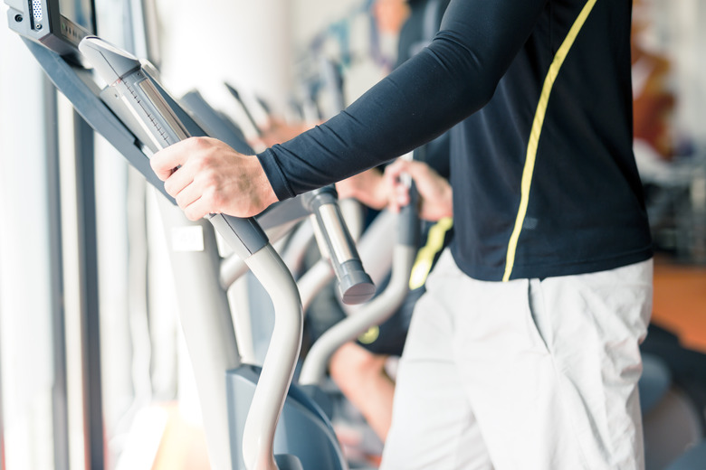 Young healthy group of people working out on elliptic trainer