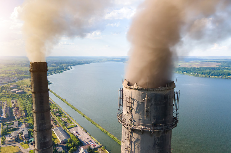 Aerial view of coal power plant high pipes with black smokestack polluting atmosphere. Electricity production with fossil fuel concept.