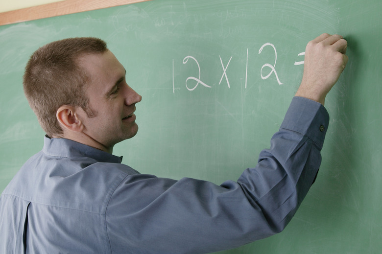 Math teacher writing on chalkboard