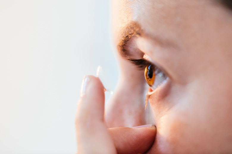 Close up of woman putting in contact lens.