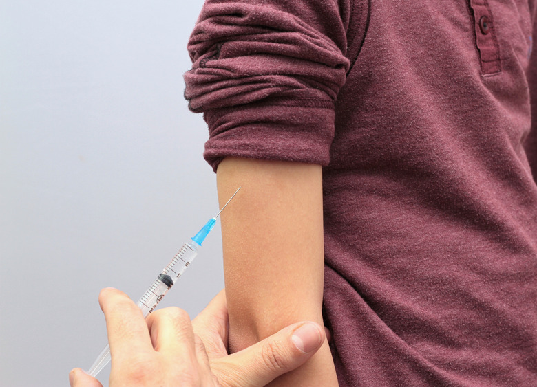 Little boy is given an injection by the doctor