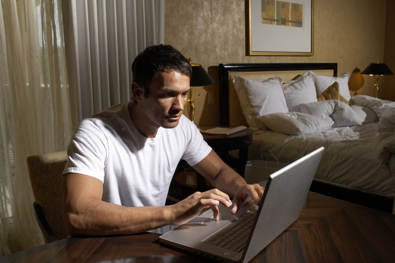 Man using laptop in bedroom