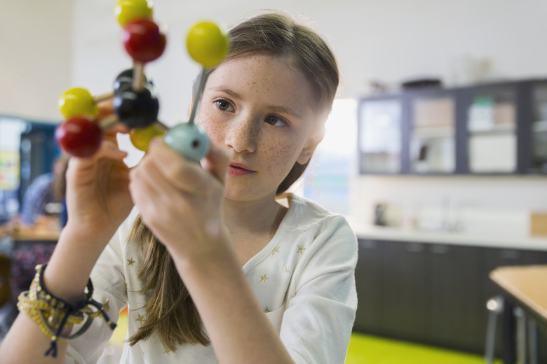 Elementary student examining molecule model