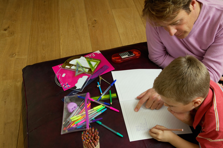 Father helping son (6-8) with homework, elevated view