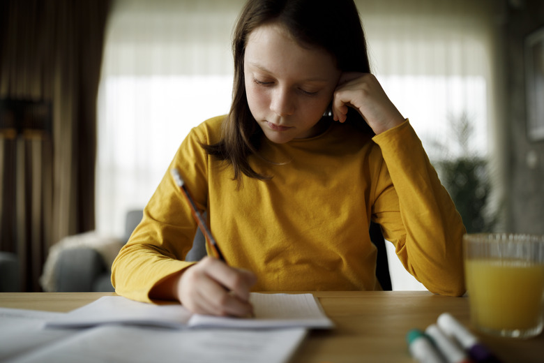 Cute young girl studying at home