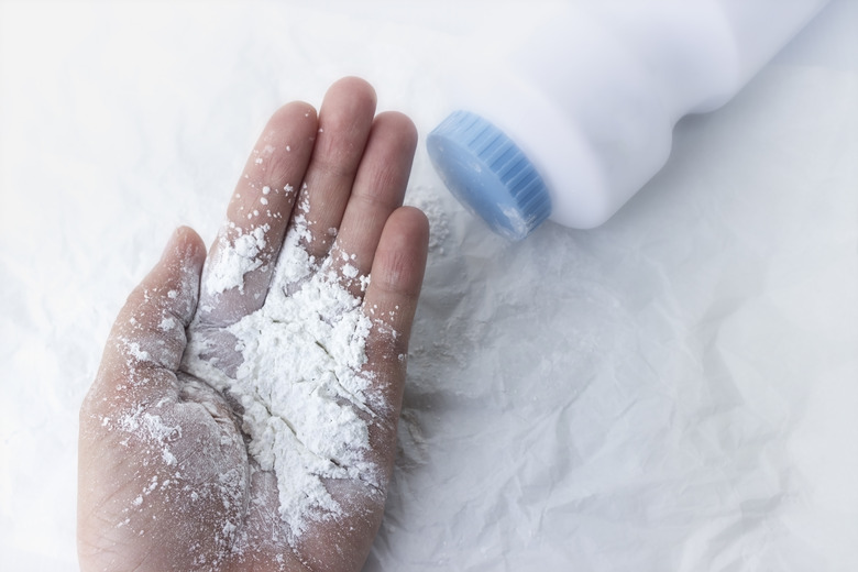 Baby powder on mother's hand, dust dangerous for health concept.