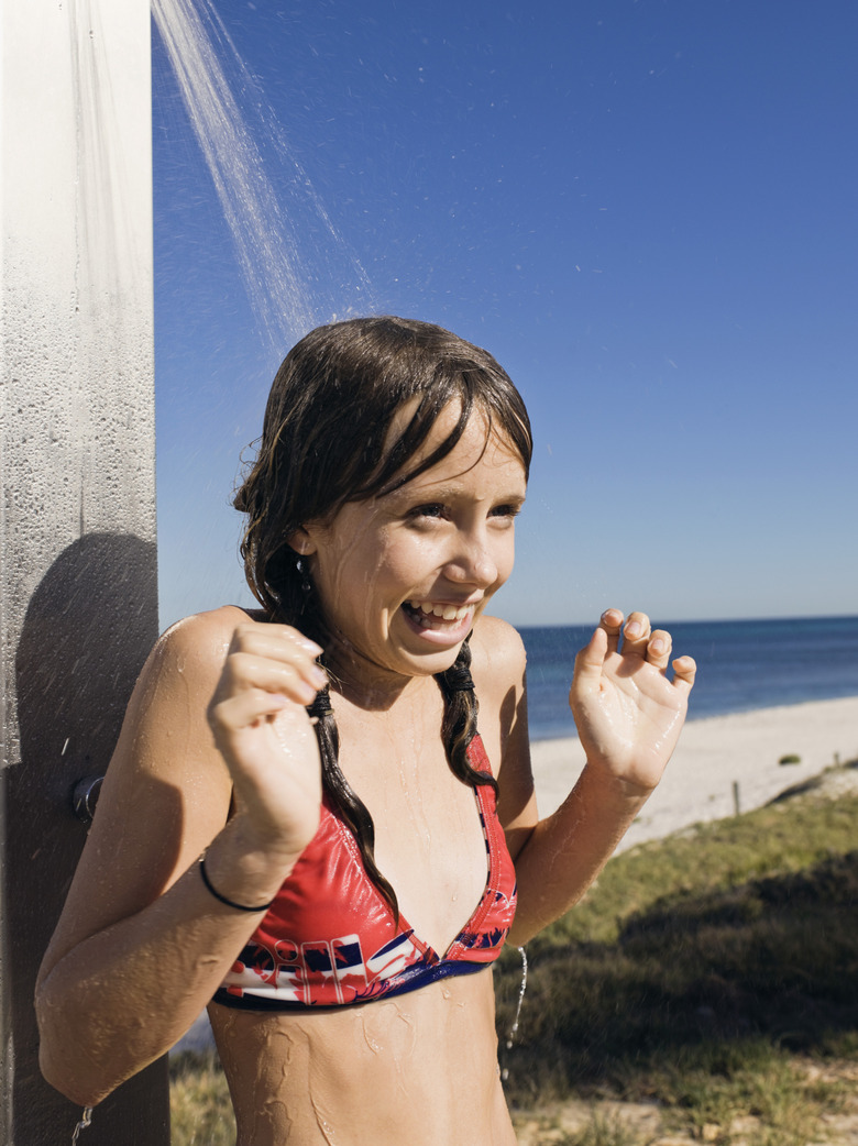 Girl showering in bikini on beach