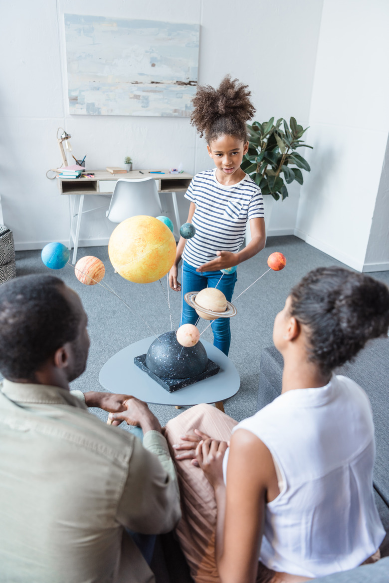 Girl telling parents about solar system