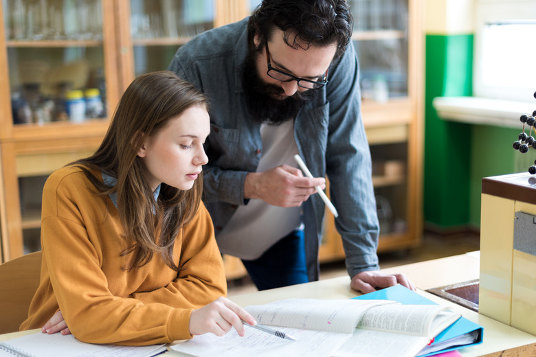 Young teacher helping his student in chemistry class. Education, Tutoring and Encouragement concept.