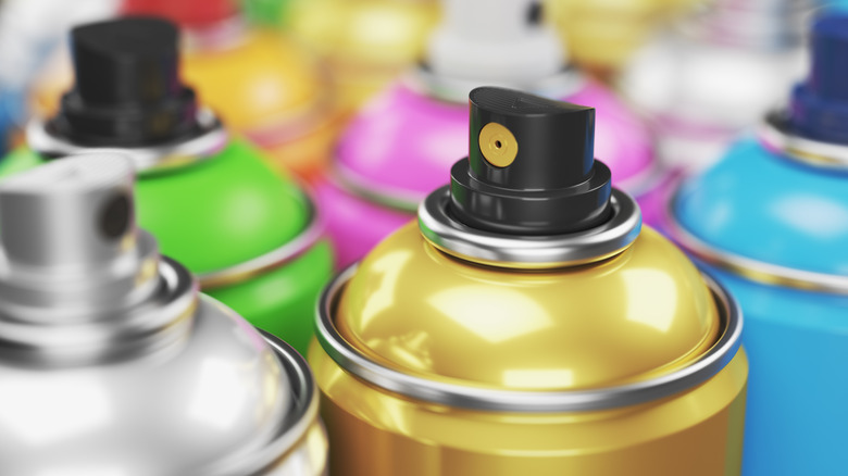 Colored spray paint cans closeup.