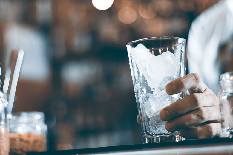 Glass with ice cubes on the background of the bar