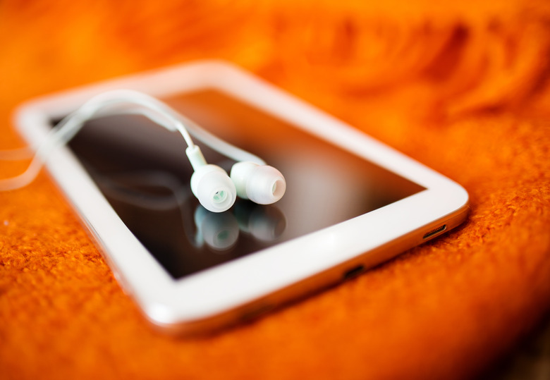 White earphones and tablet pc, close up photo, small dof