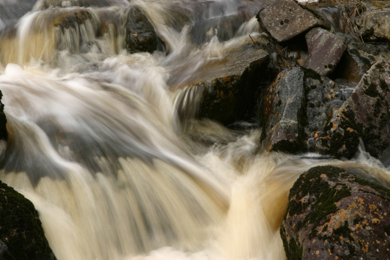 Turbid water cascading over rocks in stream