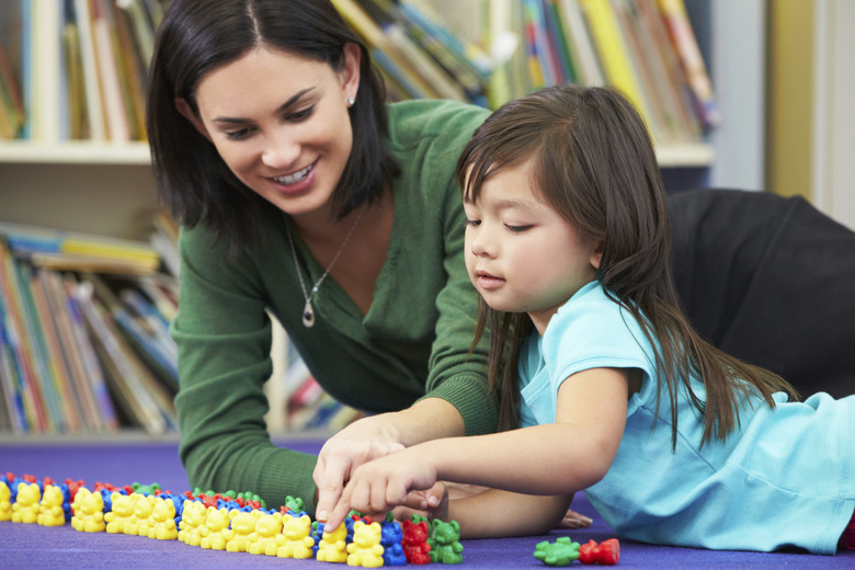 Elementary Pupil Counting With Teacher In Classroom