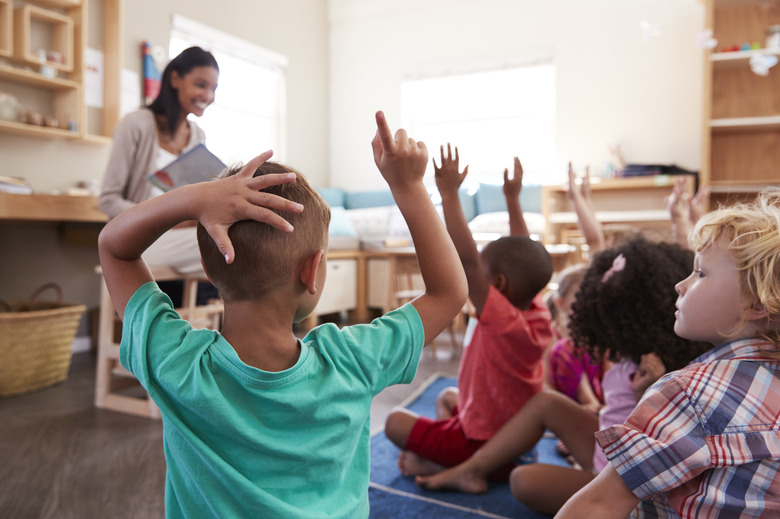 Pupils At Montessori School Raising Hands To Answer Question