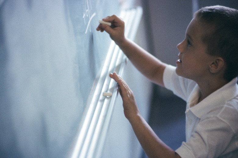 Boy writing on a chalkboard