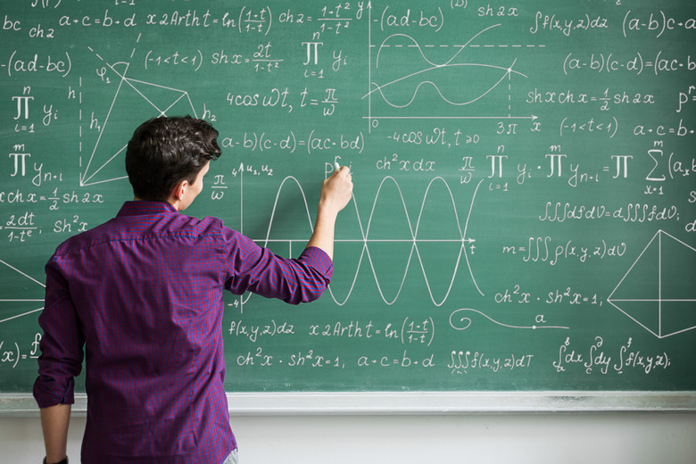 Male student writing on blackboard