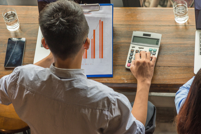 Overhead Business Angles: Young man calculate the number on sales report