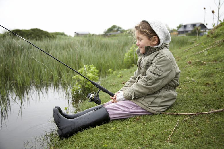 Girl fishing by a pond