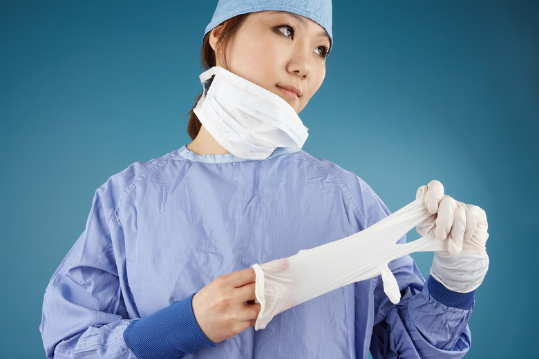 Surgeon in scrubs taking off gloves