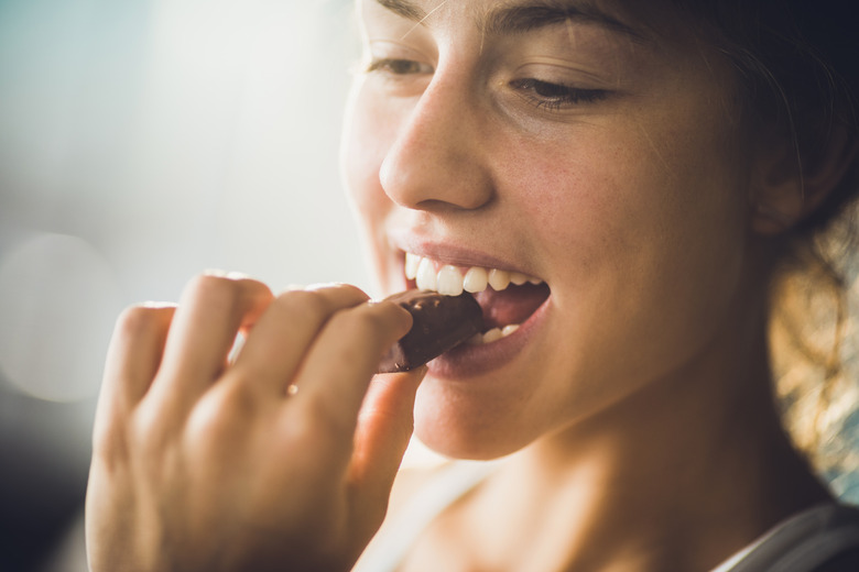 Close up of a happy woman eating chocolate.