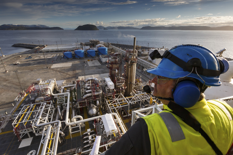 Oil industry worker looking out on a plant.