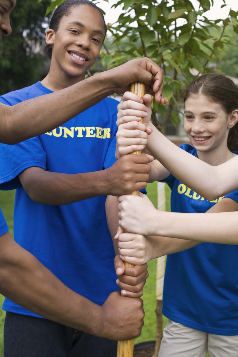 Volunteers with hands on shovel