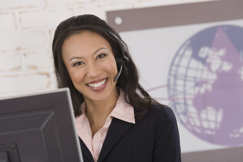 Smiling businesswoman using computer and wearing hands-free headset