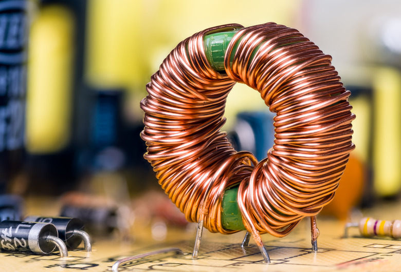 Induction coil with copper wire winding soldered on printed circuit board. Toroidal inductor