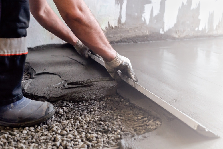 Worker levels a floor cement mortar - one of several types of composite materials