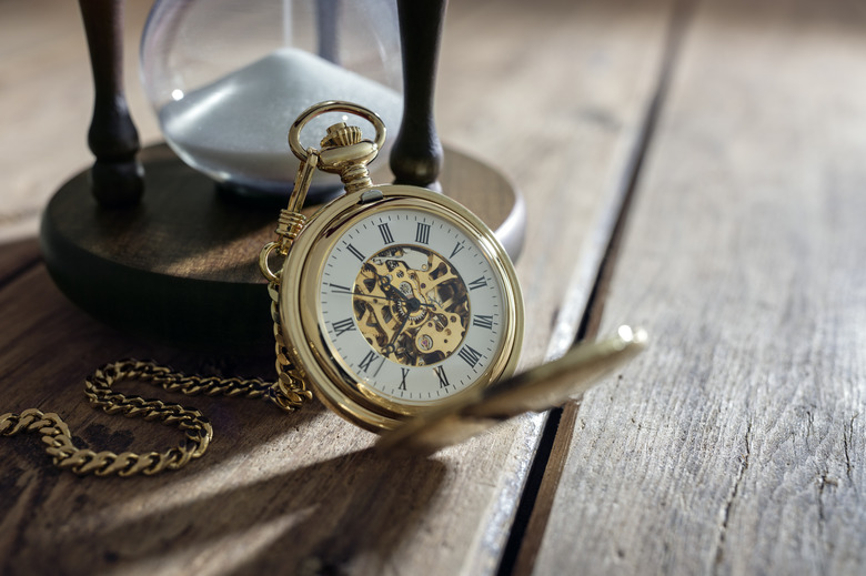 Gold pocket watch and hourglass