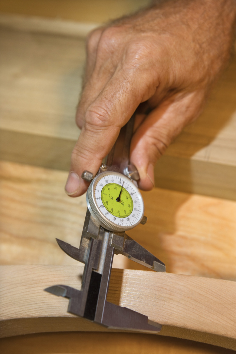 Hands measuring wood