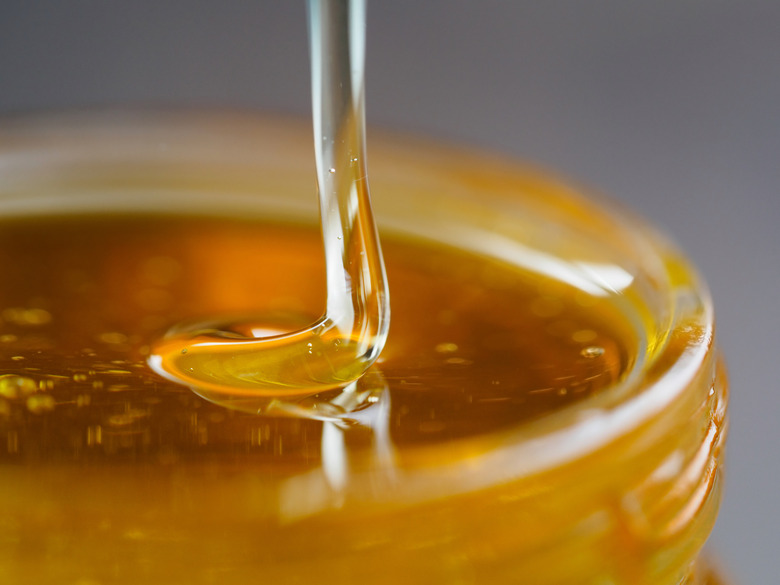 Honey falling in jar extreme close up