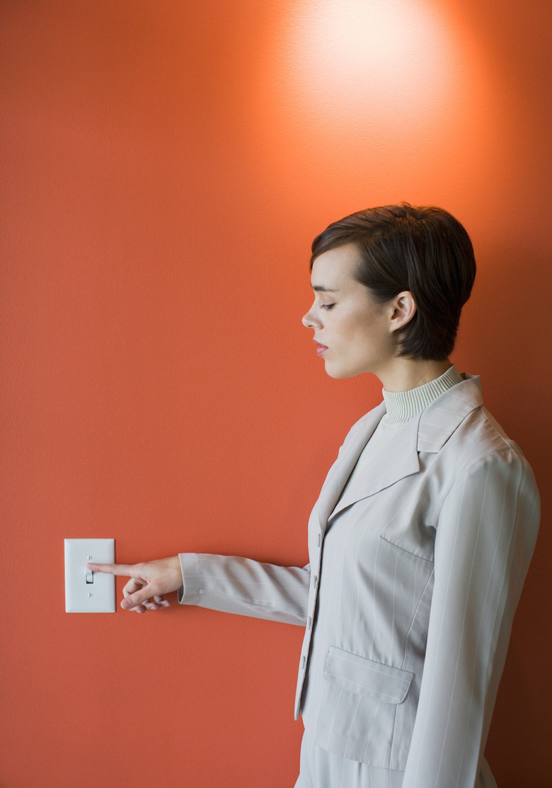 Businesswoman practicing energy conservation at office