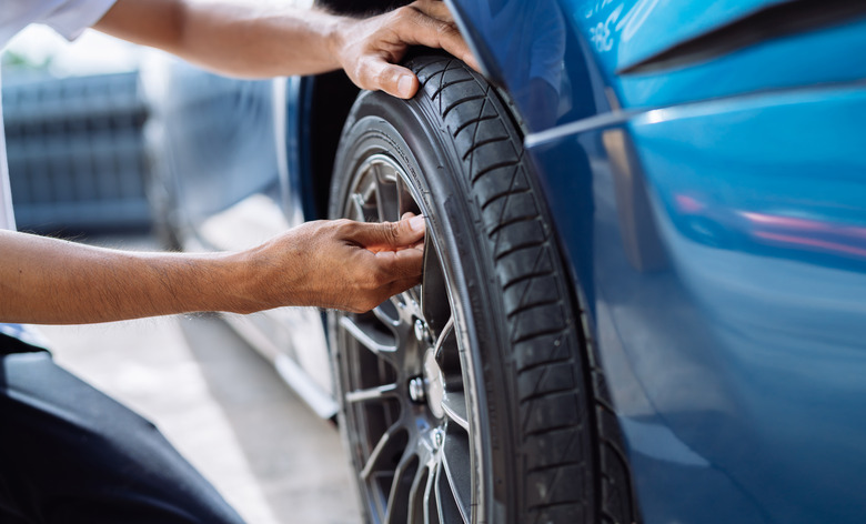 Maintenance male checking and removing tire valve filling nitrogen service on street at gas station, Safety vehicle to reduce accidents before a long travel, Blue car of man transportation lifestyle