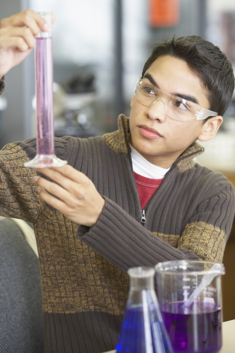 Teenage boy holding a flask in a laboratory