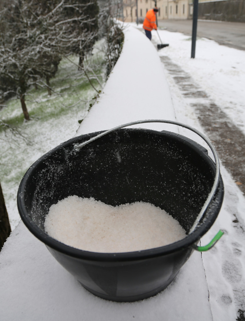 bucket with a lot of salt used to melt ice and snow from the sidewalk