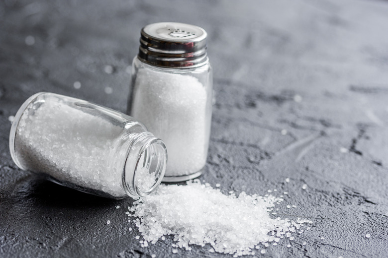 salt in bottle for spices set dark background closeup