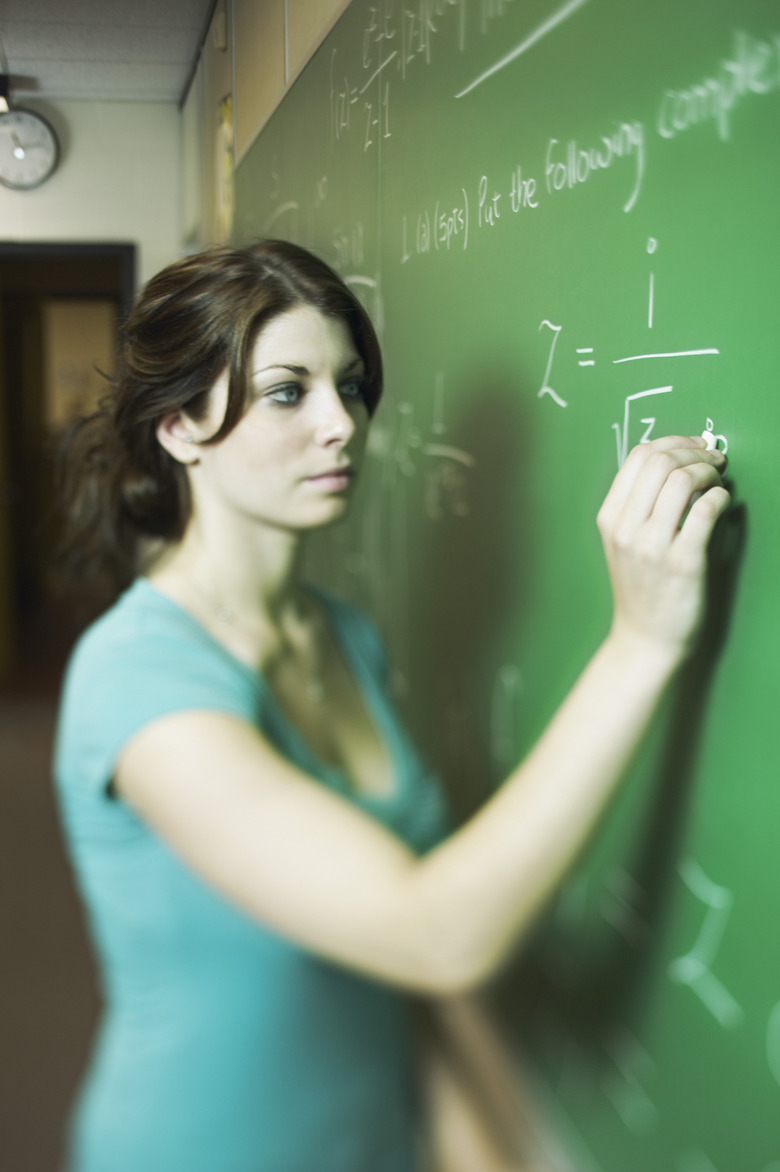 Teenage girl writing on chalkboard