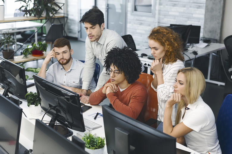 Pensive colleagues reading business information on computer