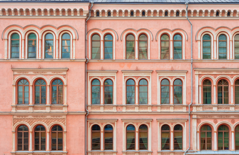 The facade of a beautiful pink city building. Windows with semicircular part