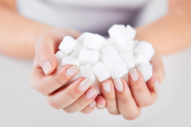 Woman holds in hands of sugar cubes