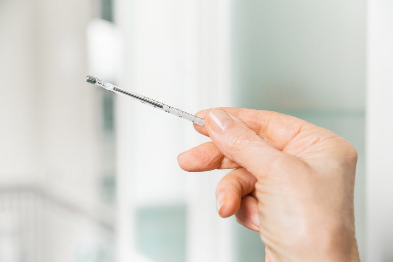 Mercury thermometer in women's hands