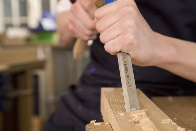 Person carving into wood with a chisel