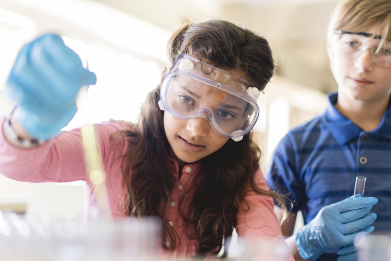 Students doing scientific experiment in classroom