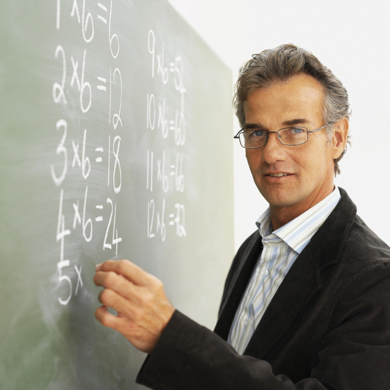 Portrait of a male school teacher writing on the blackboard