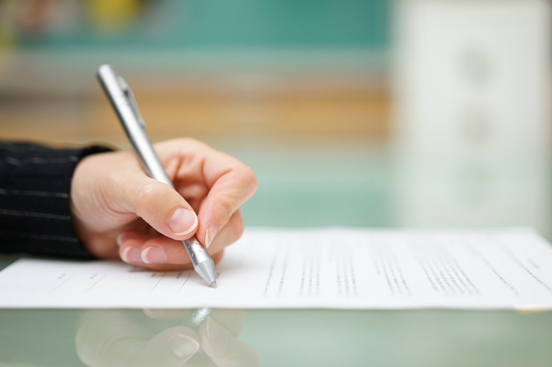 woman is filling document on glass table, shallow depth offield